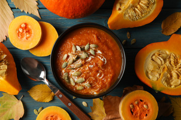 Composition with pumpkin soup with seeds on wooden background, top view
