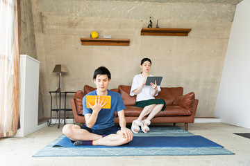 Couple using digital tablet on sofa at home