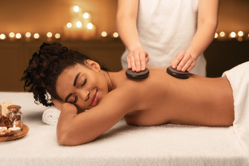 Fototapeta na wymiar Spa therapist making professional hot stone massage