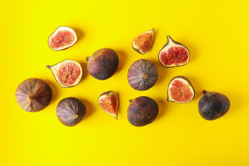 Fresh fig fruits and slices on yellow background, top view