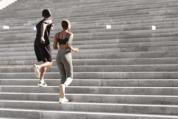 Urban Sport. Black Man And Woman Running Up Steps In City Park