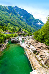 Fototapeta na wymiar View from Bridge Ponte dei Salti to Verzasca River at Lavertezzo - clear and turquoise water stream and rocks in Ticino - Valle Verzasca - Valley in Tessin, Switzerland