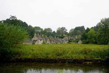 Fototapeta na wymiar Bibury, Cotswolds, England - 15 August 2020/ A view of the river and Arlington Row in Bibury on a rainy summer day