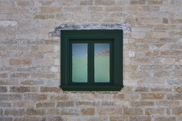 window of an old mediterranean sandstone house
with a large piece of wall