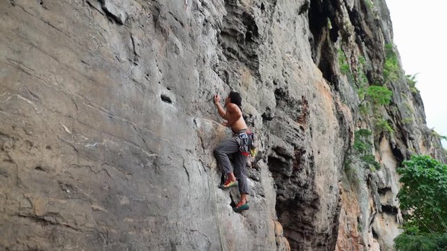 Shirtless Sportive Man Climbing Cliff