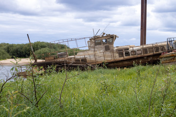 Fototapeta na wymiar Old abandoned boat on the river. Old passenger boat.