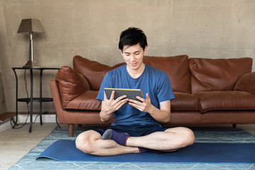 Man using digital tablet at home after exercising