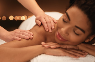 Obraz na płótnie Canvas Therapist rubbing relaxed black woman shoulders, closeup