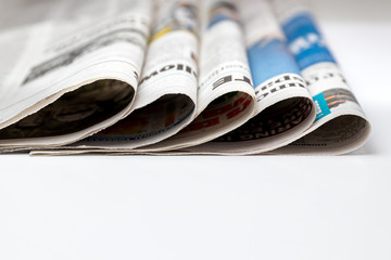 Closeup of newspapers folded and stacked in pile. Concept of print media, news and publishing...