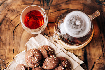 Teapot with black tea and homemade chocolate cookies on a brown natural wooden background