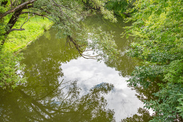 Shallow narrow river and green summer coast at daytime