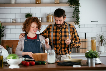 Young couple making delicious food at home. Loving couple enjoying in the kitchen..