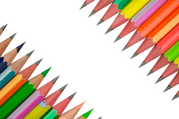 Bunch of row of different colored wood pencil crayons facing each other on white paper