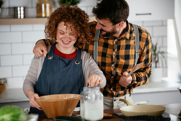 Young couple making delicious food at home. Loving couple enjoying in the kitchen..