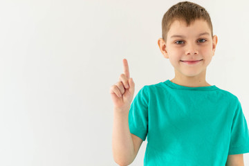boy on white background holds finger up