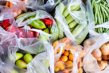 Many plastic bags from local bazaar with many vegetables and fruits