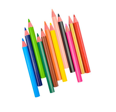 Stack of different colored wood pencil crayons scattered across a white background