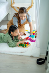 Happy asian family moher and daughter and playing with toy blocks at home. Home activities for family.
