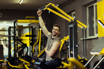 Muscular man working out in gym doing exercises