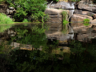 Fototapeta na wymiar Summer European river with stone banks and green trees.