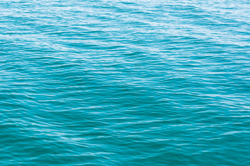 Blurred image of sea water texture in movement. Deep blue and light reflex. Background.
