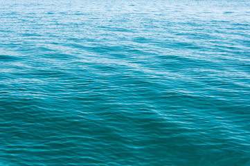 Blurred image of sea water texture in movement. Deep blue and light reflex. Background.