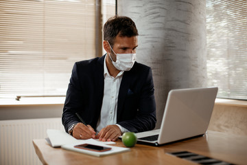Handsome businessman with medical mask. Young man working in office...