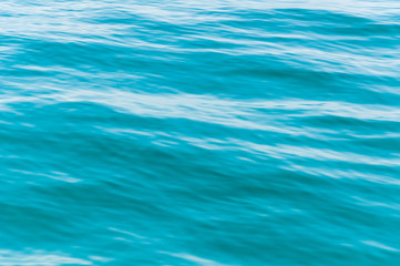Blurred image of sea water texture in movement. Deep blue and light reflex. Background.