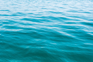 Blurred image of sea water texture in movement. Deep blue and light reflex. Background.