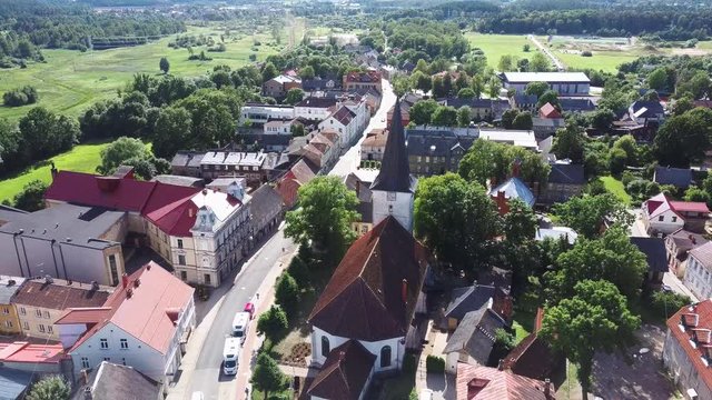 Aerial View of the  Holy Trinity Lutheran Church in Tukums, Latvia. Golden Cock Statue on the Top of Tower. Tukums City Park on the  the Background. Sunny Summer Day.