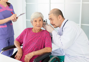 asian man use otoscope looking in ear canal of old patient, Otorhinolaryngology disease, elderly health check up - Powered by Adobe