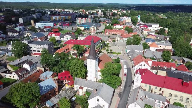 Aerial View of the  Holy Trinity Lutheran Church in Tukums, Latvia. Golden Cock Statue on the Top of Tower. Tukums City Park on the  the Background. Sunny Summer Day.