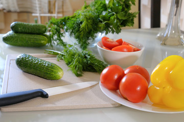 Fresh vegetables for salad on the kitchen table. Healthy food concept. Tomato, cucumber, pepper, salad.