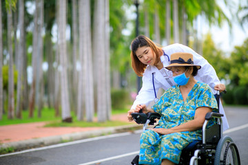 Fototapeta na wymiar Asian female doctor take care of older patient how to use the electric wheelchair.