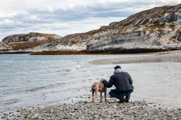 Mann und Hund genießen die Zeit am Meer