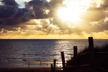 Sunset view over the beach from the top of a sand dune.