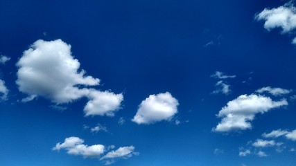Blue sky with white clouds. Peaceful sky background. Space for text.