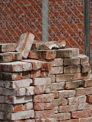 COLOR PHOTO OF PILE OF RED CLAY BRICKS IN CONSTRUCTION SITE