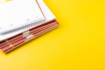 different stationary items on yellow as educational or office desk concept