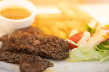 Pork steak with black pepper sauce, salad and French fries