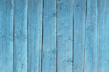 blue fence made of old wooden boards, texture and structure of wood, boards close-up, knots,...