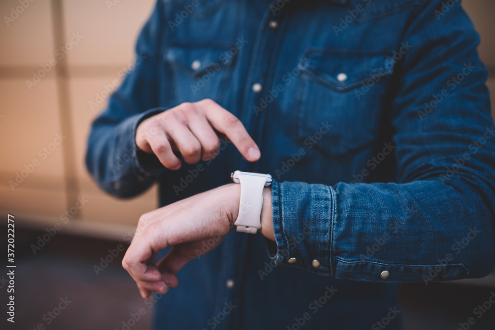 Poster cropped image on man checking notification on digital smartwatch display planning day with modern or