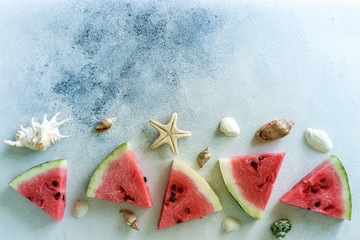 A healthy diet berry with seashells, stars and palm leaves. Sweet tasty popsicles a slice of watermelon in summer on a light background. copy space for designer