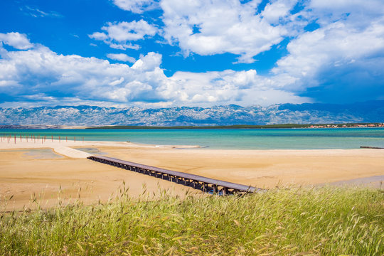 Sand lagoon near town of Nin in Dalmatia, Croatia. Adriatic coastline and blue sky with clouds. Velebit mountain in background.