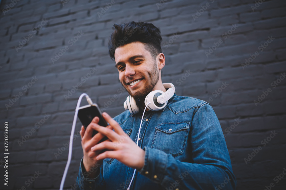Aufkleber smiling bearded hipster guy texting message on smartphone chatting in networks with friend, positive