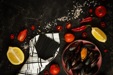  Ingredients for making black pasta with seafood close-up on a black background