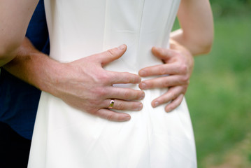 male hands hugging a woman's waist, close-up