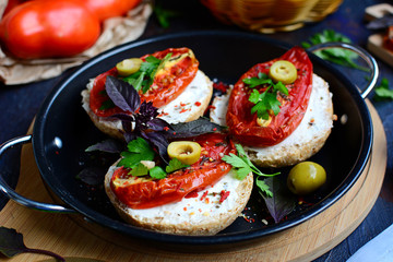 Close-up of appetizing sandwiches with sun-dried tomatoes, cheese, basil and olives.