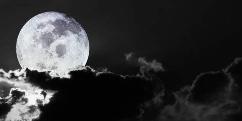 Dramatic atmosphere panorama black and white view of bright and shiny full view of Big Moon on dark sky background with soft clouds.Image of moon furnished by NASA.