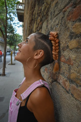 Vertical shot of attractive woman posing against a wall